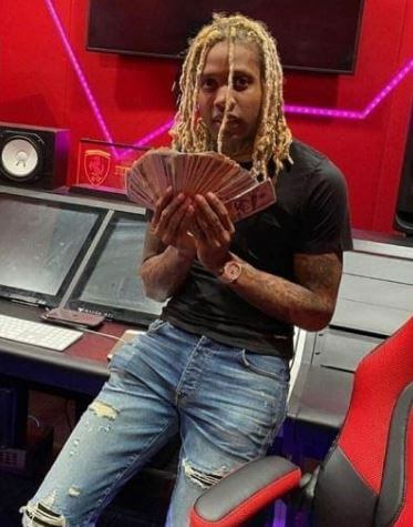 Dontay Banks son Lil Durk posing with money in his studio.